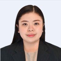 A woman with straight dark hair wearing a black blazer and beige top, facing forward against a light background.